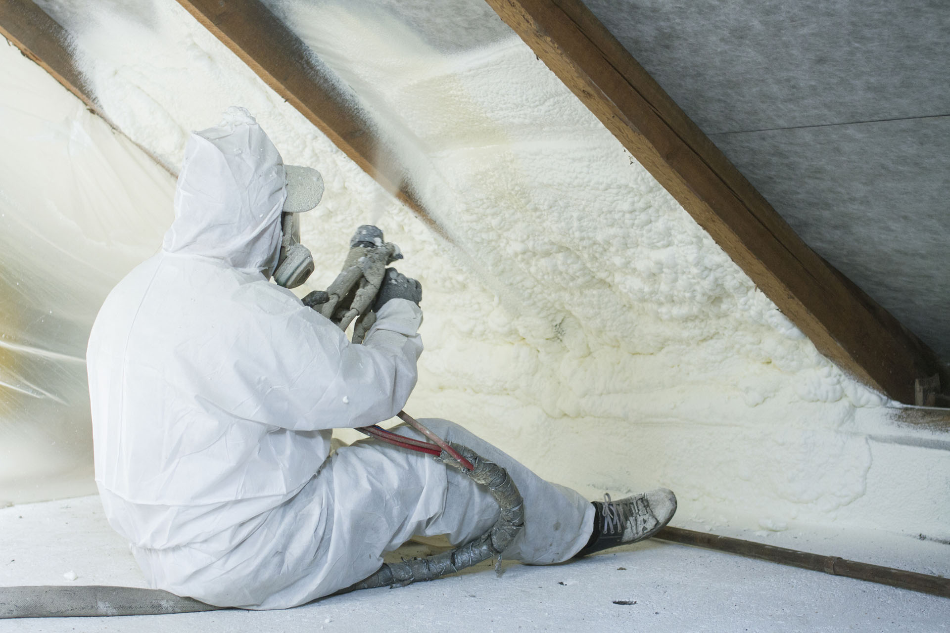 SprayTight Inc technician applying spray foam insulation in a Michigan attic