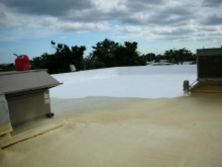 White protective roof coating applied over spray foam base on commercial roof